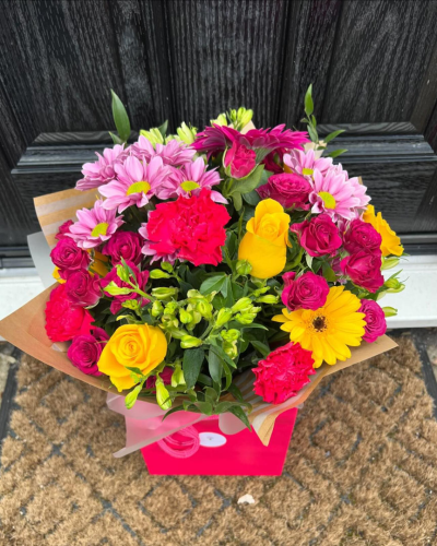 Petal Paradise - A lively bouquet featuring a bright mix of vibrant seasonal blooms. Complemented by lush green foliage and presented in a beautiful packaging, this arrangement is perfect for adding a pop of colour to any occasion