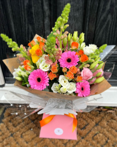 Blushing Meadow - A stunning collection of pink and green seasonal flowers in toning packaging. This bouquet is designed to impress and uplift any space.