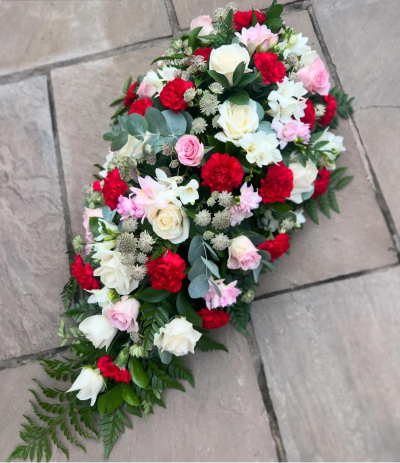 Single Ended Spray SYM-305 - This single ended spray is made using symbolic red roses for the perfect loving tribute. Same day delivery may not be possible on this design – please contact us to discuss your requirements.