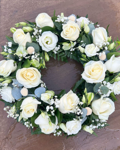 Classic Wreath in White -SYM-321 - This classic wreath made with mixed white and cream flowers is suitable for a lady or a gentleman. This type of funeral arrangement needs at least one working days’ notice for delivery. Same day delivery is not possible.