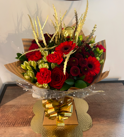 Festive Grandeur - Add a touch of magic to your Christmas gifting with this luxurious bouquet, featuring a blend of red, white, and green flowers adorned with festive additions. Perfectly arranged in a festive-themed box, it's designed to enchant and delight.